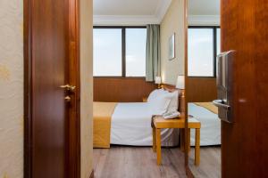 um quarto de hotel com uma cama e uma janela em Hotel The Brand em Roma