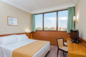 a hotel room with a bed and a desk and a television at Hotel The Brand in Rome