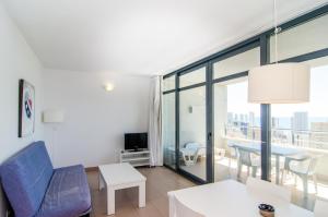 a living room with a couch and a table at Apartamentos con terraza Torre D'Oboe by Renthas in Benidorm