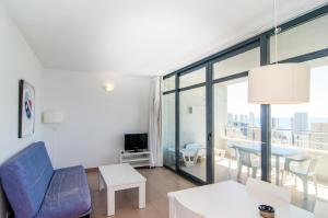 una sala de estar con un sofá y una mesa en Apartamentos con terraza Torre D'Oboe by Renthas, en Benidorm