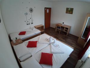 a room with two beds with red and white pillows at House Naomi in Grabovac