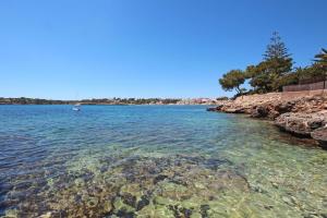 a view of the water near a rocky shore at Aparthotel Niu d´Aus in Portopetro