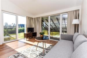 a living room with a couch and a table at Atsipūskit in Palanga