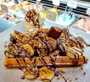 um prato de waffles com chocolate e gelado em Gabana Baleal Beach no Baleal