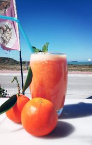 een drankje en drie sinaasappels op een tafel bij Gabana Baleal Beach in Baleal
