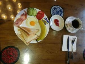 a plate of breakfast food with eggs and fruit on a table at Longji Holiday Hotel in Longsheng