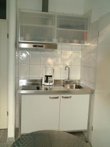 een kleine keuken met een wastafel en een magnetron bij Gästeapartment Kübel in Uedem