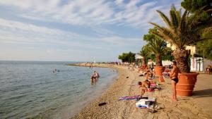 een groep mensen op een strand vlakbij het water bij Apartma LaVela in Izola