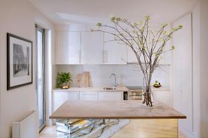 a kitchen with a table with a vase of flowers on it at No.5 Maddox Street in London
