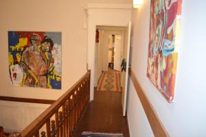 a hallway with a staircase with paintings on the wall at Hotel Gran Sarmiento in Buenos Aires