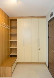 Un vestidor con gabinetes blancos y madera. en White Lagoon - Luxurious 1BD Flat near Kavarna by Flat Mаnager, en Kavarna