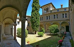 a large building with an archway in front of a yard at CHÂTEAU CAGNINACCI B&B in San-Martino-di-Lota