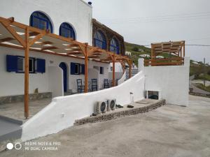 a large white building with a fireplace in front of it at Kampanelia Village Suites in Fira