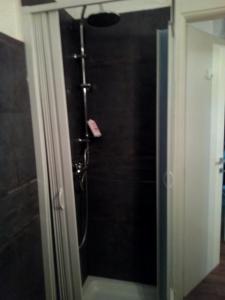 een douche in een badkamer met een glazen deur bij La casa di Marco in Ventimiglia