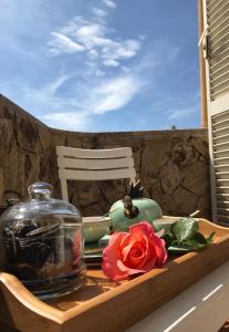 ein Tablett mit einem Glas Glas und einer Rose auf dem Tisch in der Unterkunft Royal Suite in Tissi