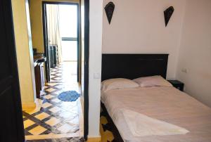 a small bedroom with a bed and a hallway at Bouad Luxury Apartment in Taghazout