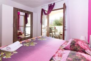 a bedroom with a large bed and a mirror at Apartments Luka in Pag
