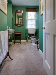 a green bathroom with a toilet and a sink at Glamis House in Forfar +54 photos