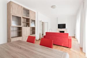 ein Wohnzimmer mit einem roten Sofa und roten Stühlen in der Unterkunft Santa Rita Roomy Apartments in Padua