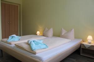 a bed with two towels on top of it at Hotel und Campingstell und Zeltplatz an der Talsperre im Harz in Altenbrak