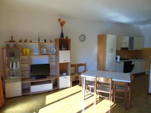 een woonkamer met een tafel en een keuken bij Villa Fidia in Lignano Sabbiadoro