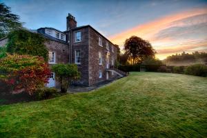 an old brick house with a grass field in front of it at Glamis House in Forfar