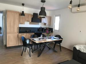 uma cozinha com mesa e cadeiras num quarto em Ultra em Lovran