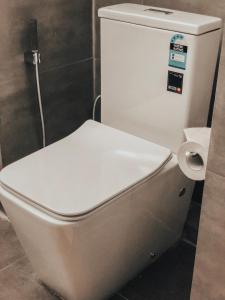 a white toilet in a bathroom with a toilet paper dispenser at Pinnacle boutique villas in Galle