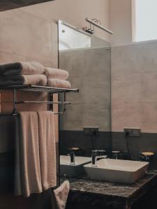 a bathroom with a sink and a mirror and towels at Pinnacle boutique villas in Galle