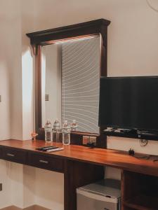 a desk with a television and two water bottles on it at Pinnacle boutique villas in Galle