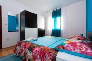 1 Schlafzimmer mit einem Bett mit Blumendecke in der Unterkunft Apartments Luka in Pag