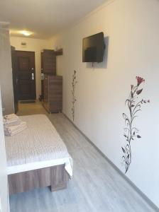 a bedroom with a bed and a tv on a wall at Studio Gul Mona Saturn in Saturn