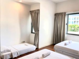Cette chambre comprend 2 lits et une fenêtre. dans l'établissement Borneo Coastal Residence @ IMAGO Mall, à Kota Kinabalu