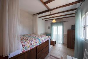 a bedroom with a bed and a window at Studios Aeolos Kalymnos in Myrties