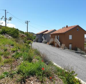 Une rangée de maisons sur le côté d'une route dans l'établissement Slavica apartments 3, à Sveti Juraj