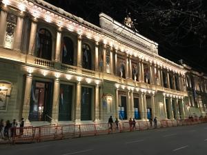 un edificio iluminado con gente caminando delante de él en Cordoba Inn departamentos temporarios en Córdoba