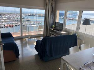 een woonkamer met uitzicht op een haven bij Apartaments la Catifa in Palamós