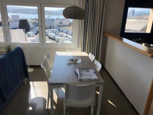 - une table et des chaises dans une chambre avec fenêtre dans l'établissement Apartaments la Catifa, à Palamós