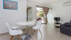 a living room with a white table and white chairs at Apartmani Memories I in Baška