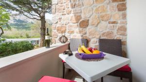 a table with a bowl of fruit on it at Apartmani Memories I in Baška
