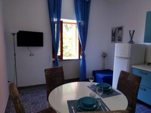 uma cozinha com uma mesa e cadeiras e um frigorífico em Villa Rosa Cilento em Caprioli