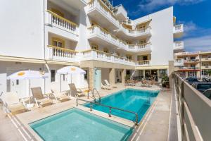 uma piscina em frente a um grande edifício branco em Irini Apartments em Hersonissos