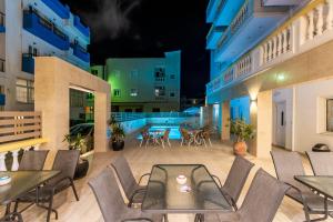 an outdoor patio at night with tables and chairs at Irini Apartments in Hersonissos