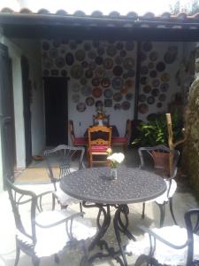 a table and chairs on a patio with plates on the wall at Casa de Aldea la Galeria habitación en casa particular in poo de Llanes