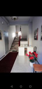 a room with a staircase with red flowers on the floor at B&B La Vittoria in Sulmona