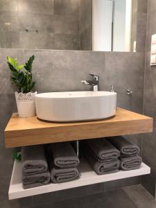 a bathroom with a sink and towels on a shelf at Modern Flats in Kielce