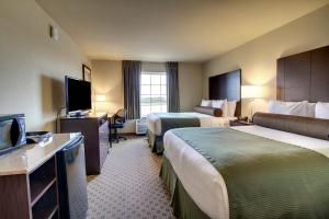 a hotel room with two beds and a flat screen tv at Cobblestone Inn & Suites - Brillion in Brillion