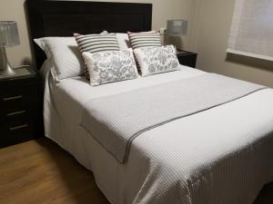 sypialnia z białym łóżkiem z poduszkami w obiekcie Apartamento AGRELO w mieście Bueu