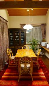 ein Esszimmer mit einem Tisch und Stühlen in der Unterkunft Guest House 合歓木（ねむ） in Hokuto