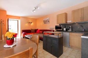 eine Küche und ein Wohnzimmer mit einem Tisch und einem Sofa in der Unterkunft Très bel appartement 4 pers Chalet Les Lupins - Les 2 Alpes in Les Deux Alpes